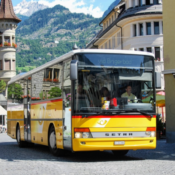 Yellow Setra coach bus parked in a mountain town street