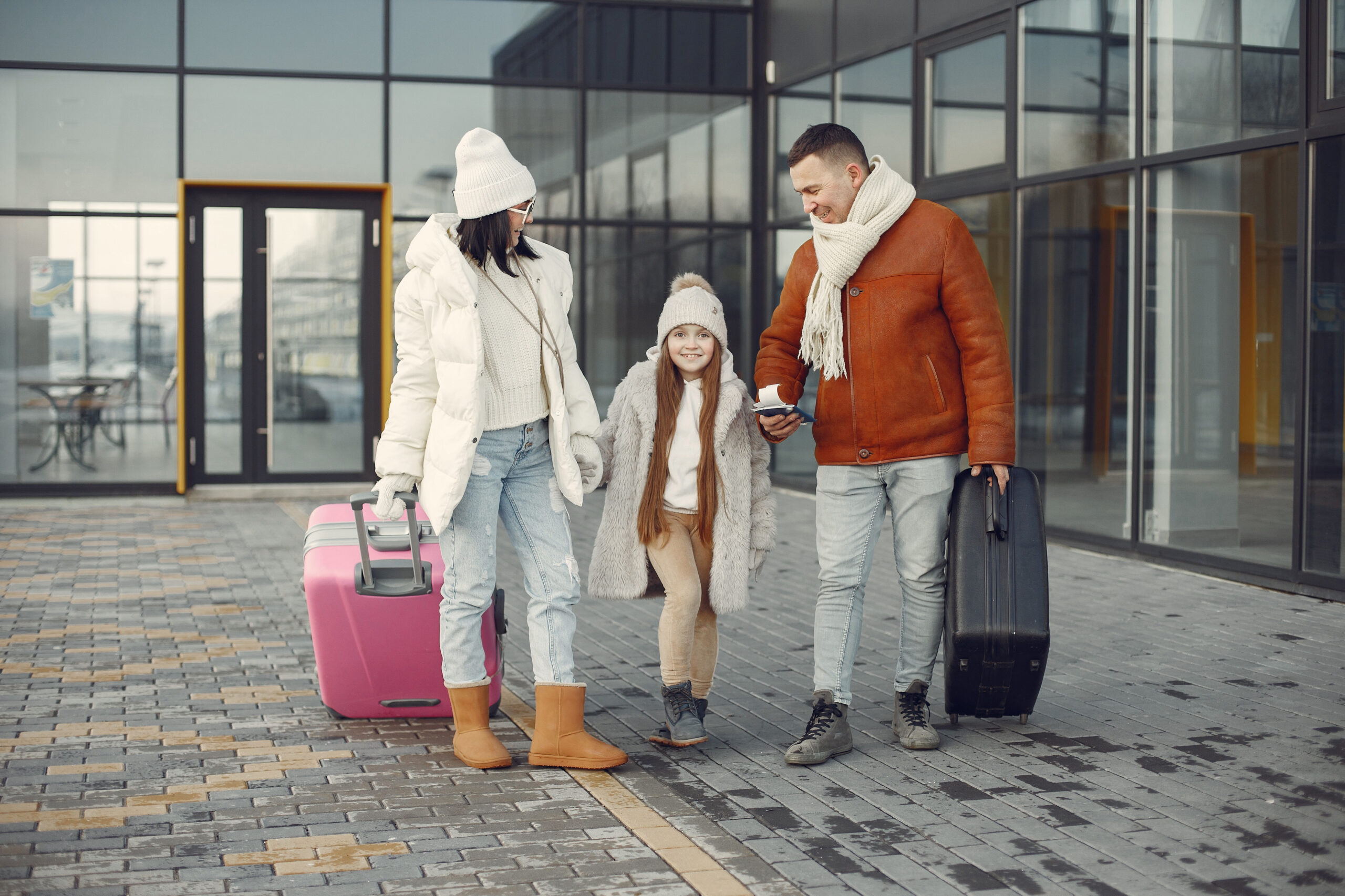 Designer replacement image: parents and children preparing for a UK trip with suitcases an